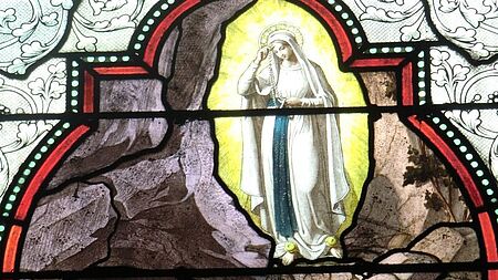 Glasfenster in der Basilika der Unbefleckten Empfängnis in Lourdes: die erste Erscheinung