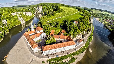 Luftbildaufnahme mit Weitwinkel vom idyllischen Kloster an der Donau, sonniges Wetter