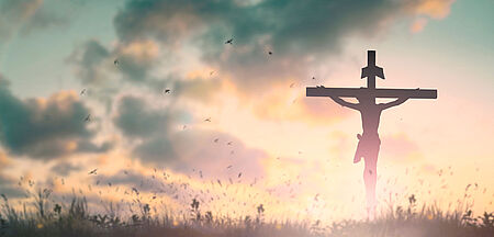 Silhouette eines Jesus am Kreuz vor Sonnenaufgang