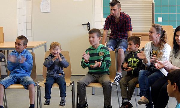 Mehrere Kinder sitzen auf Stühlen in einem Sprachkurs