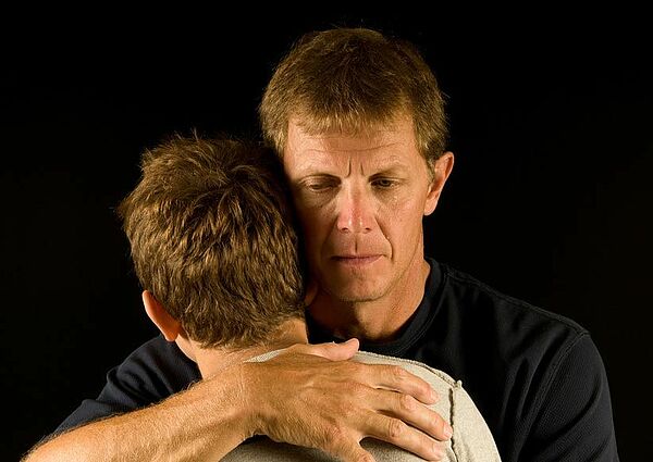 Vater umarmt Sohn
